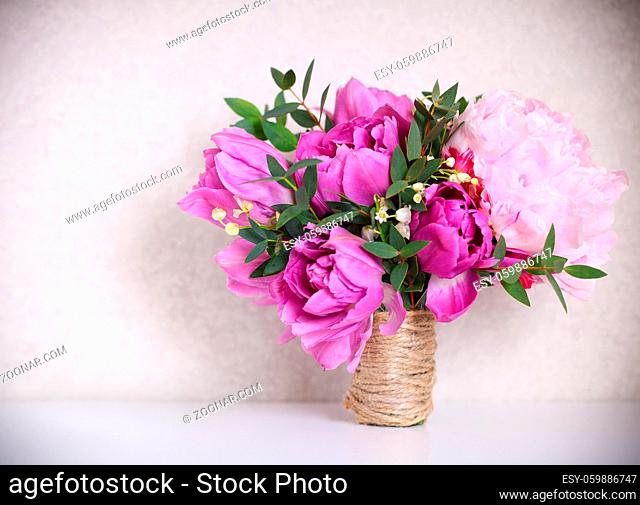 Wedding bouquet of a pink peonies, tulips and lily of the valley