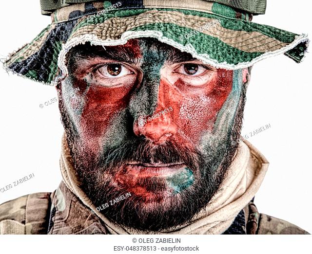 Special forces United States in Camouflage Uniforms studio shot. Wearing jungle hat, Shemagh scarf, painted with red and green face