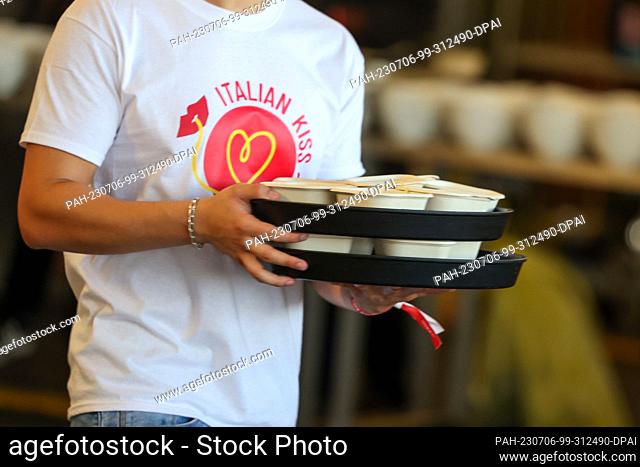 06 July 2023, Berlin: Waiters bring the pasta to the tables at the world record attempt ""Italian Kiss"" of the restaurant chain Vapiano at Tempelhof Airport