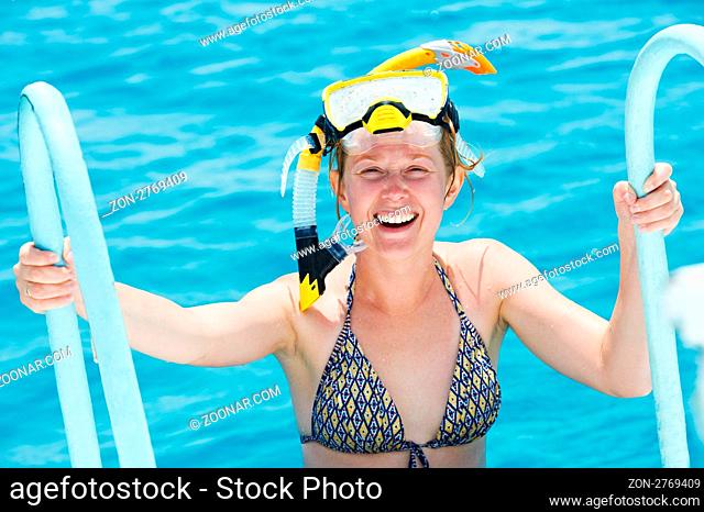 active smiling woman going out of red sea with snorkel equipment