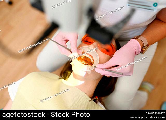 Female dentist and patient with opened mouth in clinic, top view, stomatology. Doctor in uniform, medical worker, medicine and health, professional teeth care