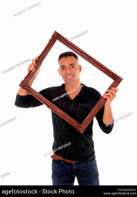 A happy east Indian man standing behind a brown picture frame in a.black dress shirt with a big smile, isolated for white background