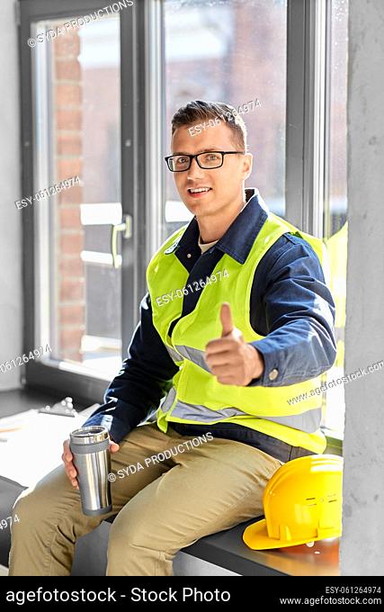 happy builder with tumbler showing thumbs up