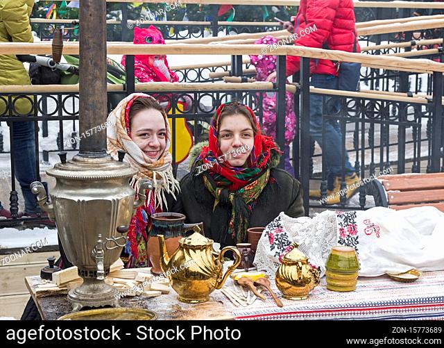 Moscow, Russia - February 17, 2018: Costume performance on Shrovetide festivities - girls dressed in the fashion of the early 20th century drink tea from a...