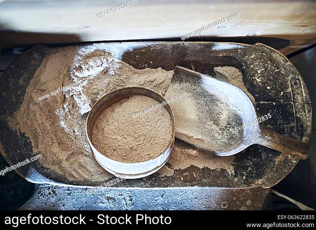 Sifting flour. Bolting flour. Flour in wooden bowl. Old rustick kitchen utensils