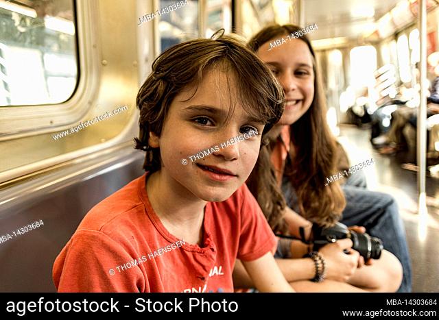 Myrtle Av, New York City, NY, USA, 14 years old caucasian teenager girl and 12 years old caucasian teenager boy - both with brown hair and summer styling in a...