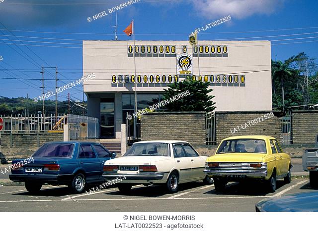 Trinidad and Tobago Electricity Commission building. Cars parked in foreground. Walls. No entry sign