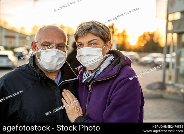 Couple wearing protective mask looking at camera