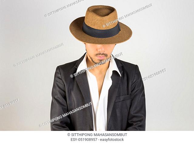 Portrait Man in Black Suit and White Shirt and Hat Fashion on Front View. Man in black suit with brown straw hat on grey background in smart style