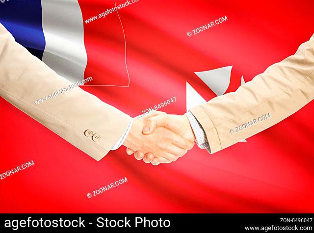 Businessmen shaking hands with flag on background - Wallis and Futuna
