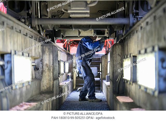 13 July 2018, Germany, Wittenberge: An employee works under an electric locomotive in the workshop of DESAG subsidiary Schienenfahrzeugbau Wittenberge (SFW)