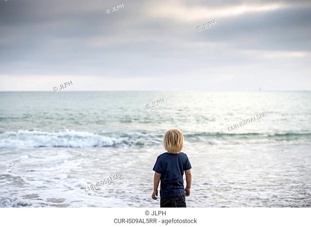 Rear view of boy gazing out to sea, Dana Point, California, USA