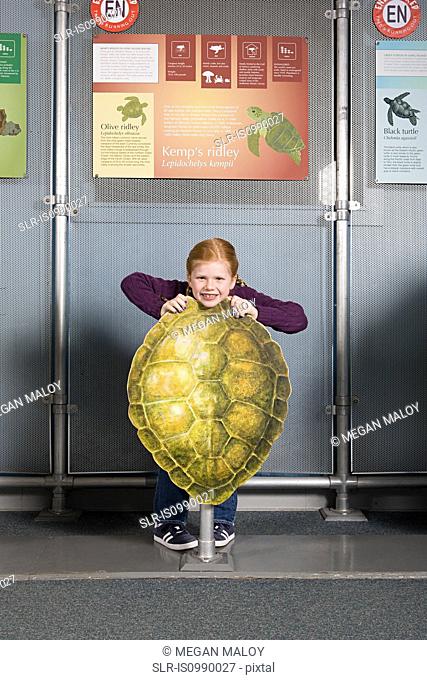 Girl standing behind kemps ridley sea turtle shell