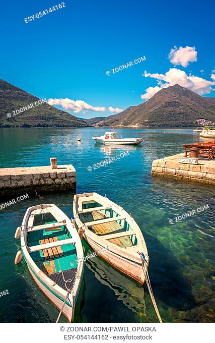 Two small fishing boats on the shore in the beautiful Perast town in the Kotor Bay, Montenegro
