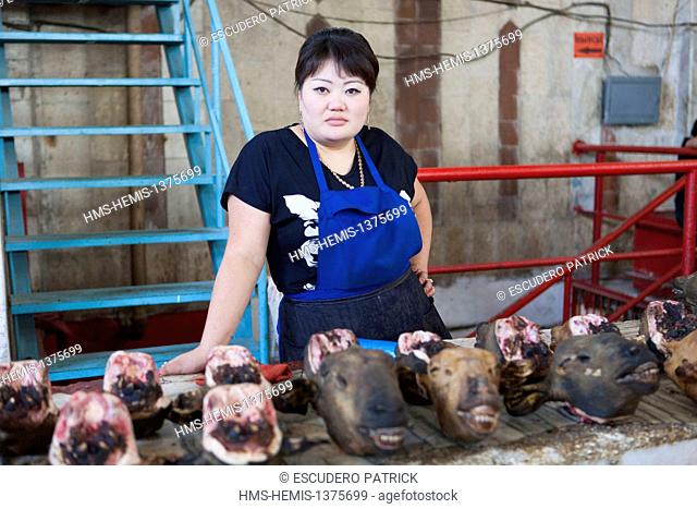 Kyrgyzstan, Chuy Province, Bishkek, woman selling sheep heads at the Osh covered market