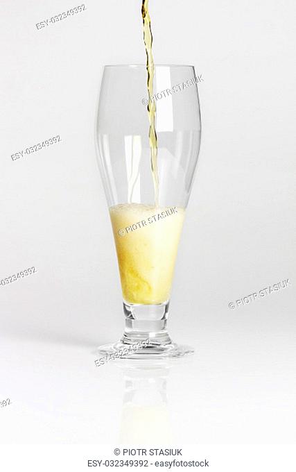 Lager beer pouring into glass from bottle isolated on white background