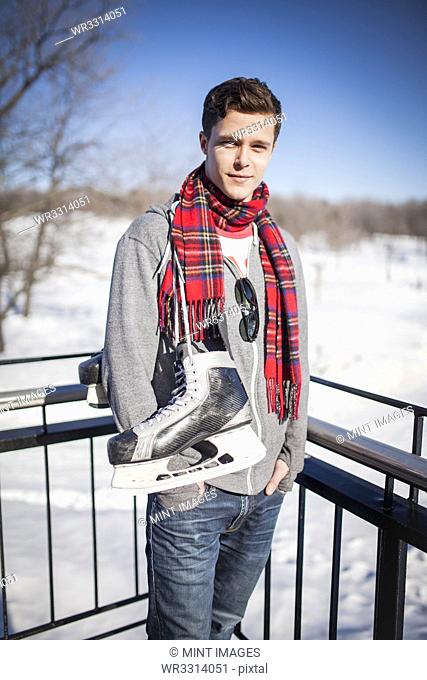 Caucasian man carrying ice skates in winter