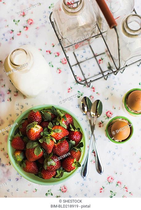 Strawberries, eggs and milk on table