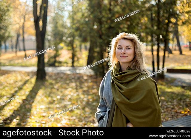 Beautiful woman wearing shawl in autumn park