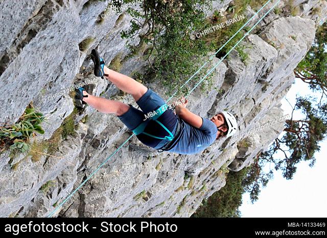 young man climbing in the climbing garden sonnenplatten scharnitz karwendel mountains, scharnitz, tyrol, austria