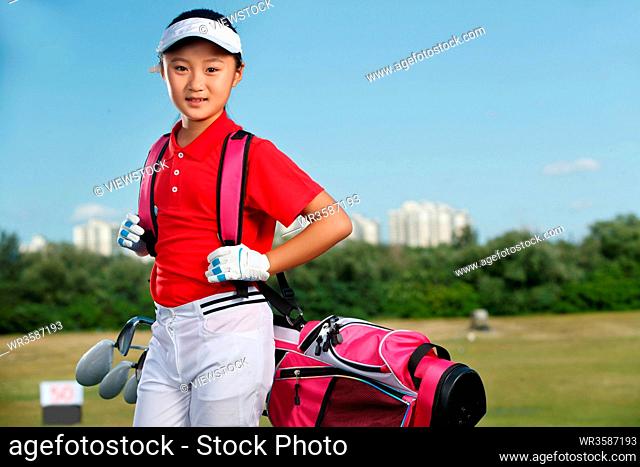 Outdoor happy children carrying a golf bag