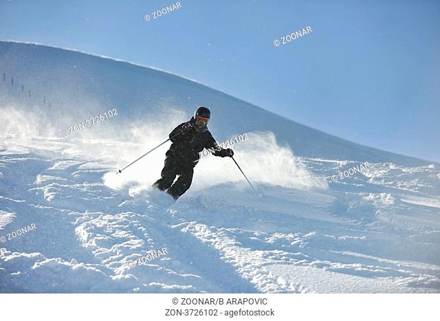man ski free ride downhill at winter season on beautiful sunny day