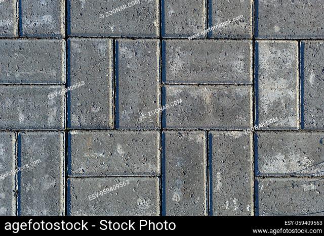 Gray texture of paving stones. Close-up of stone tiles for sidewalks