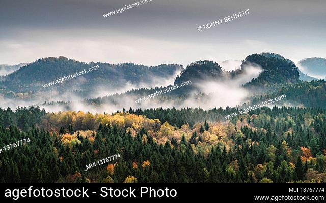 View of the misty Lorenzsteine in the autumnal Elbe Sandstone Mountains