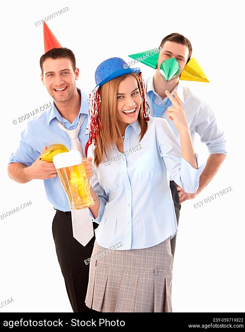 Attractive young colleagues having party fun in office, laughing, wearing party hat