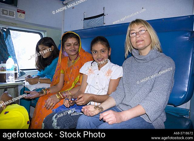 Tourist gets henna treatment on board by a little girl