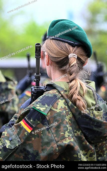 30 April 2022, Bavaria, Munich: A female soldier has her hair braided into a pigtail, taken during a roll call at the Fürst Wrede Barracks