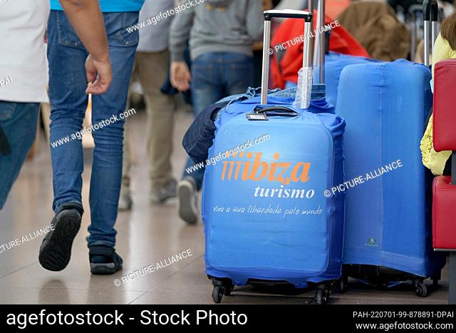 01 July 2022, Hamburg: Suitcases of air travelers stand on a terrace in Terminal 1 at Hamburg Airport. With the start of the summer vacations in...