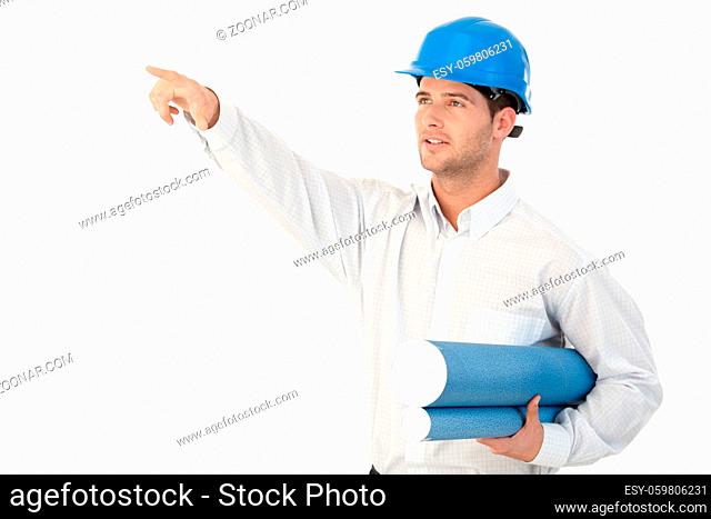 Young architect on site inspection, wearing hardhat, pointing to distance