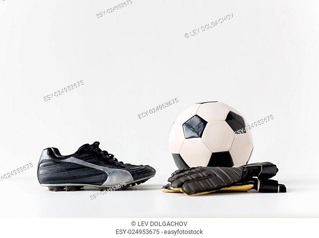 sport, soccer, football and sports equipment concept - close up of ball, boots and goalkeeper gloves
