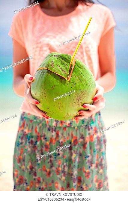 Closeup a coconut in hands of young happy girl