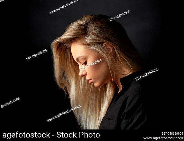 Dramatic studio portrait of a beautiful young woman on a dark background