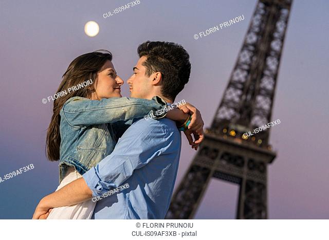 Young couple embracing in moonlight, Paris, France