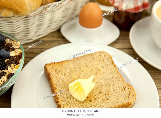 französisches Frühstück mit croissant, Saft und marmelade auf einem Holztisch