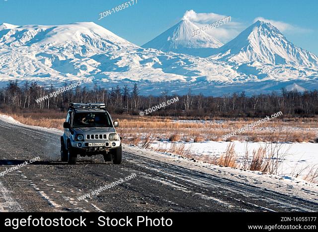 Japanese Sport Utility Vehicle Suzuki Jimny driving along road on background beautiful winter landscape travel destinations - active Kluchevskoy Volcano