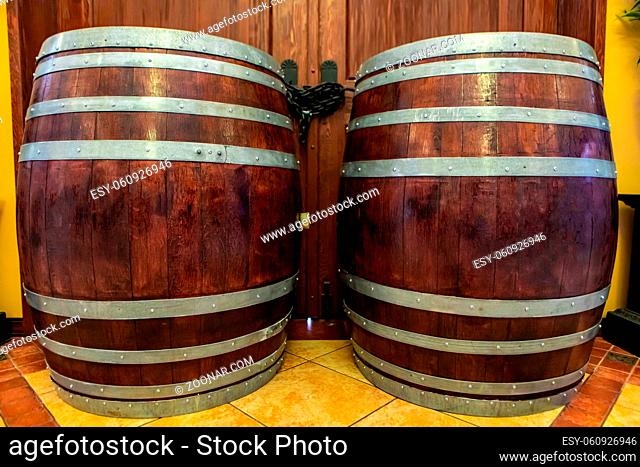 two old big oak brown wooden traditional barrels with iron rings, wine aging, beer, alcohol drink storage, winery tasting room interior decor