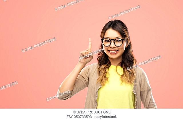 asian woman in glasses or student with finger up