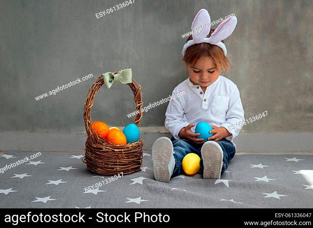 Cute Little Boy Dressed as a Bunny with Basket Full of Colorful Easter Eggs. Egg Hunting. Happy Christian Spring Holiday