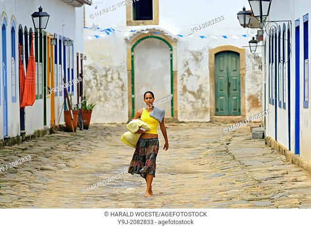 Local brazilian woman walking through the historic center; Paraty, Espirito Santo, Brazil. The beautiful colonial town of Paraty has been a UNESCO World...