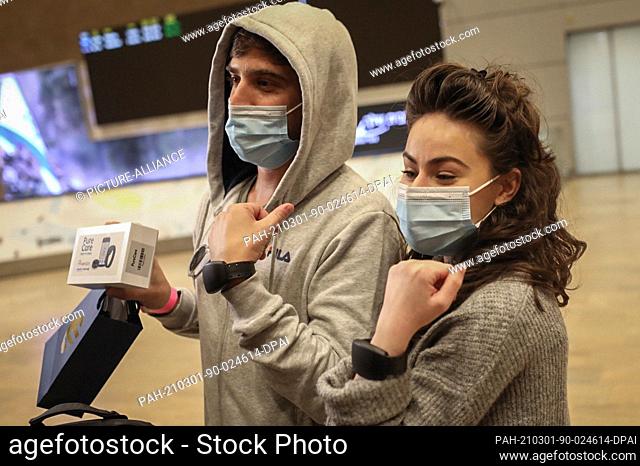 01 March 2021, Israel, Lod: Israelis who arrived with Arkia flight 232 from Frankfurt, wear electronic bracelets on their wrists before leaving Ben Gurion...