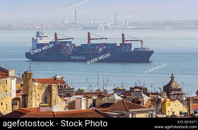 Lisbon, Portugal. Container ship on Rio Tejo seen over Lisbon rooftops