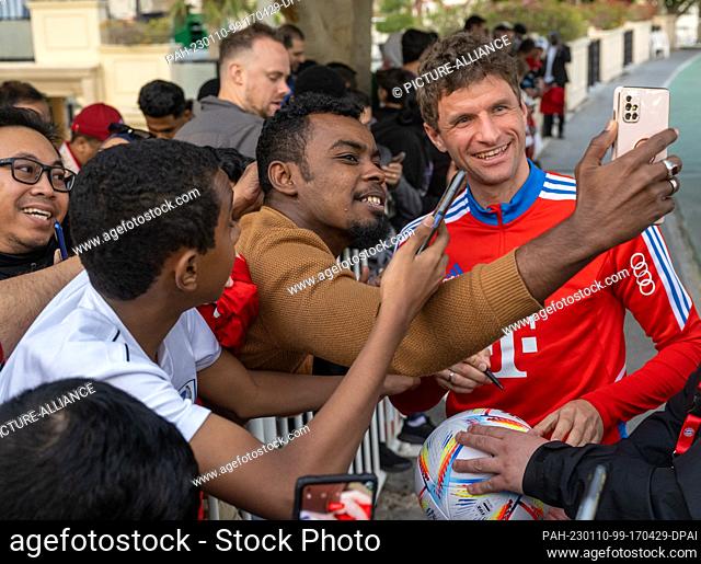 10 January 2023, Qatar, Doha: Thomas Müller of FC Bayern München signs autographs for waiting fans in the early evening at Aspira Sports Park