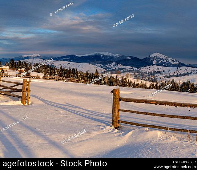 Morning countryside hills, groves and farmlands in winter remote alpine mountain village