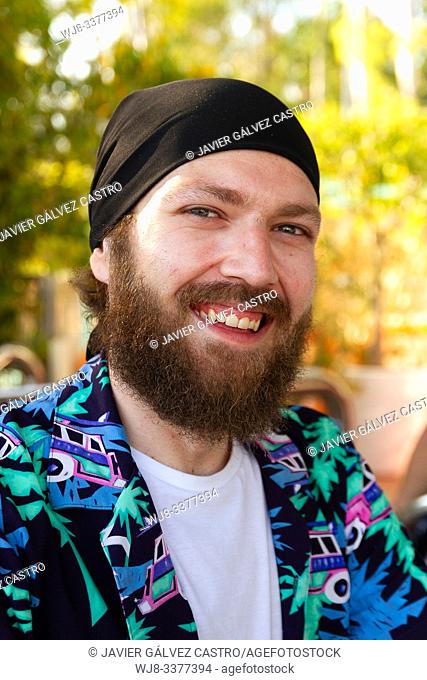 portrait of smiling young man with beard and headscarf