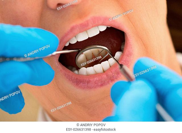 Close-up Of Woman Patient Examining Her Teeth