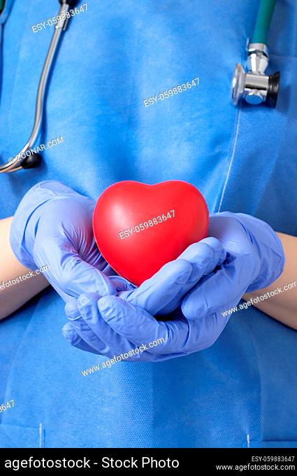 Female doctor holding a red heart shape
